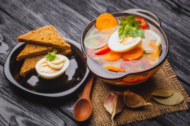 Siyah ahşap arka plan üzerinde bir tencerede erişte ile taze sebze çorbası