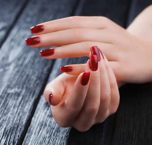 黑色木桌上美丽的红色修指甲 — 图库照片