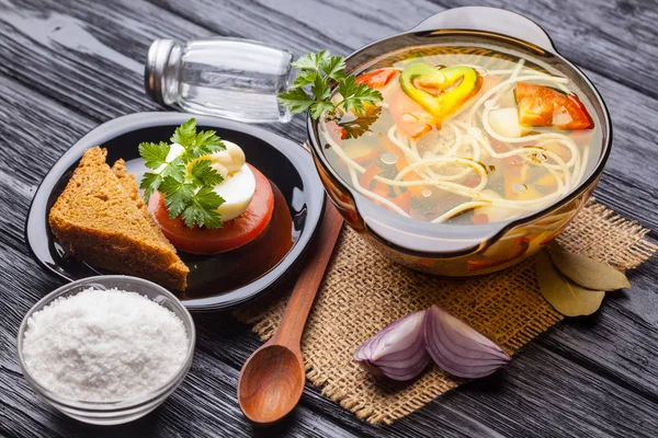 黒の木製の背景に鍋に麺と新鮮な野菜スープ — ストック写真