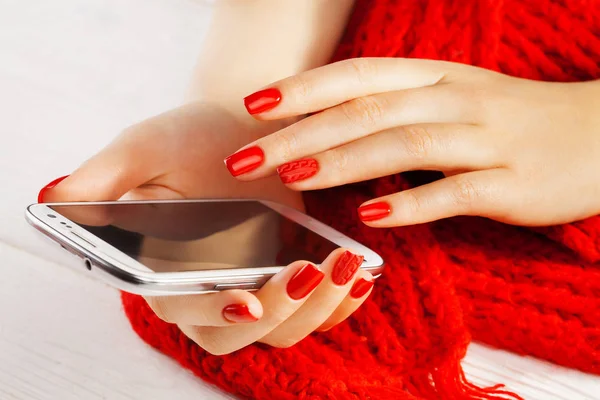 Rote Maniküre Mit Smartphone Und Rotem Strickschal Auf Dem Weißen — Stockfoto