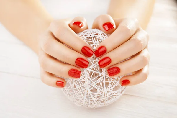 白の木製テーブルの上の糸の白いボールと赤いマニキュア — ストック写真