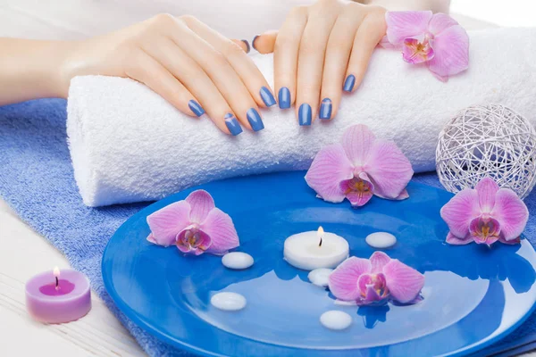 Piękny Niebieski Manicure Wystrojem Orchidei Ręcznik Biały Drewniany Stół Spa — Zdjęcie stockowe