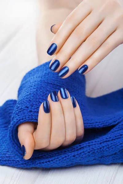 Manucure Bleue Avec Une Écharpe Tricotée Bleue Sur Table Bois — Photo