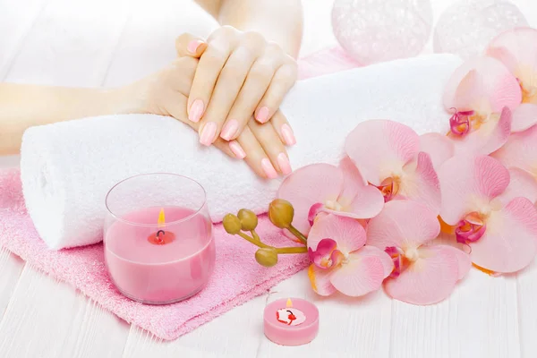 美丽的粉红色美甲装饰 毛巾和蜡烛上的白色木桌 — 图库照片