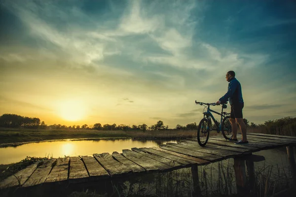 Der Radfahrer Bewundert Den Wunderbaren Sonnenuntergang Auf Der Brücke — Stockfoto