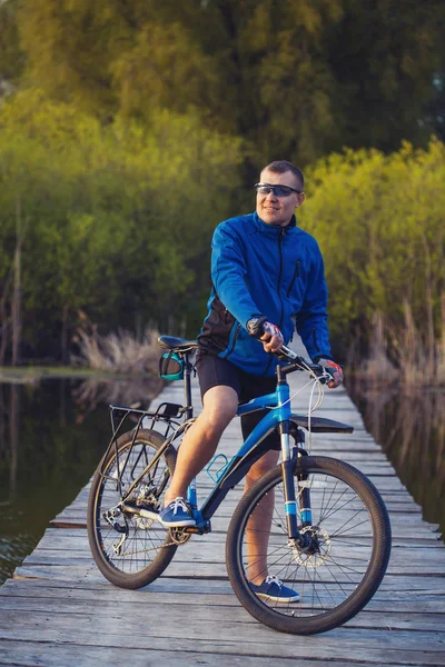 Radfahren Mann Fährt Auf Holzbrücke Über Den Fluss — Stockfoto