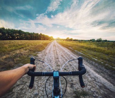 bisikletçi ile Cyclocross bisikletle bataklığı toprak yolda gidiyor. Birinci şahıs bakış