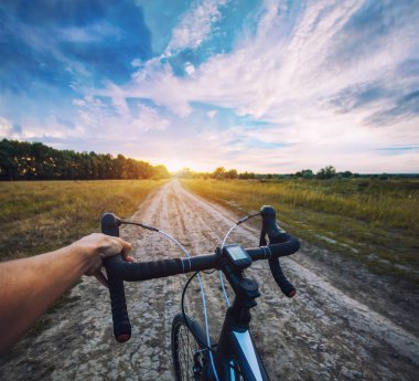 bisikletçi ile Cyclocross bisikletle bataklığı toprak yolda gidiyor. Birinci şahıs bakış