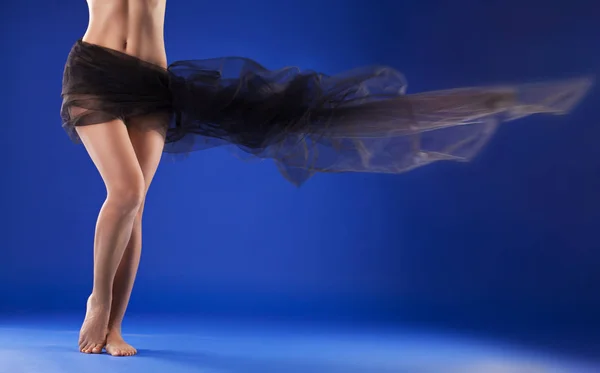 Beautiful female body with black fabric loop on a blue background — Stock Photo, Image