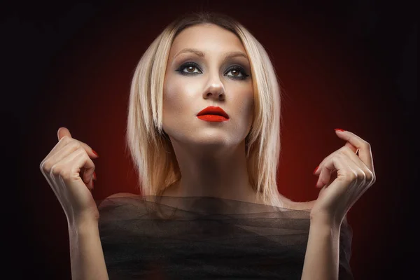 Portrait of a blond woman. evening make-up on the red background — Stock Photo, Image