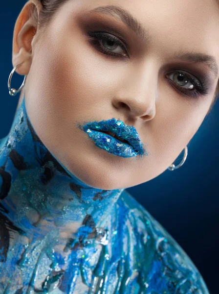 Kreatywny turkus makijaż i body art na niebieskim tle. — Zdjęcie stockowe