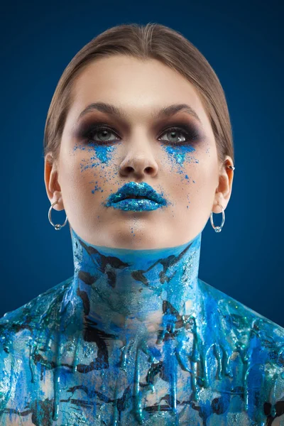 Kreatywny turkus makijaż i body art na niebieskim tle. — Zdjęcie stockowe