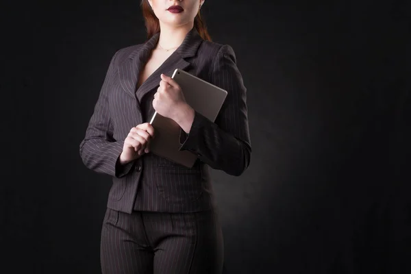 Happy young business woman posing over dark wall background. — Stock Photo, Image