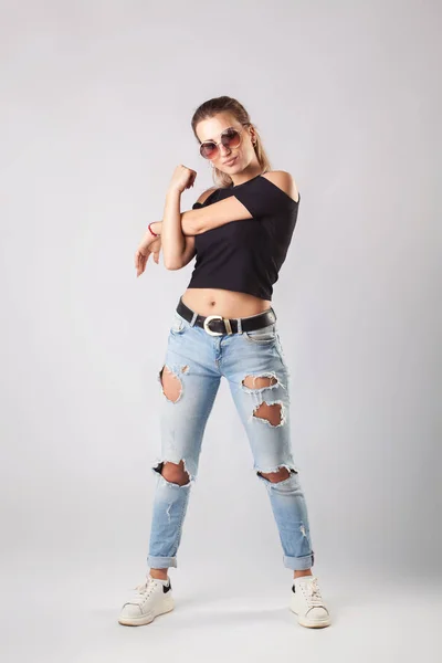 Lachende aantrekkelijke vrouw in jeans en T-shirt poseren en kijken naar camera. — Stockfoto