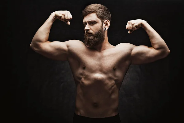 Ung stark man bodybuilder på svart bakgrund. — Stockfoto