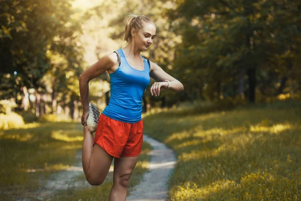 Pěkná ženská sportovec cvičila před tím, než proběhne lesem. — Stock fotografie