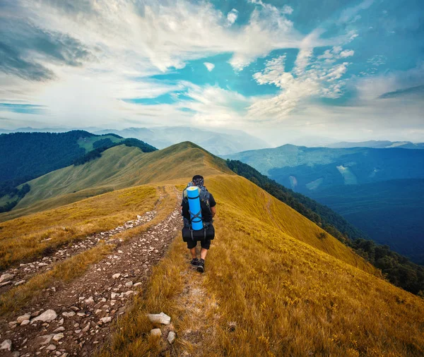 A tourist walks along a mountain meandering trail — Stock Photo, Image