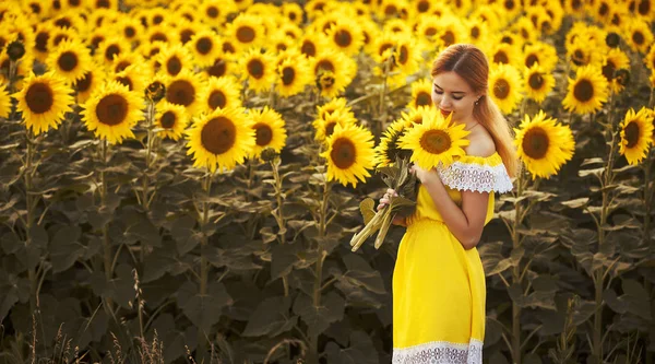 Roztomilá žena v poli s kvetoucí slunečnice — Stock fotografie