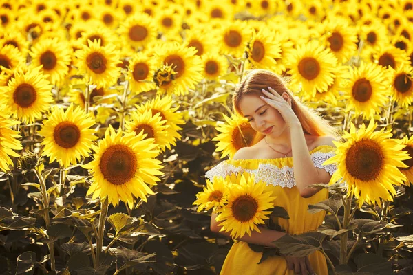 Roztomilá žena v poli s kvetoucí slunečnice — Stock fotografie