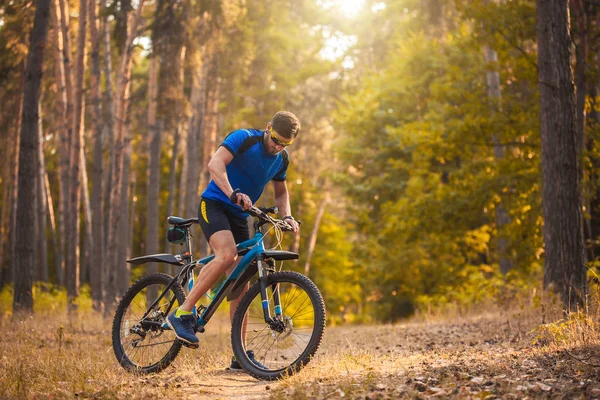 Brodaty człowiek rowerzysta jeździ w lesie na rowerze górskim. — Zdjęcie stockowe