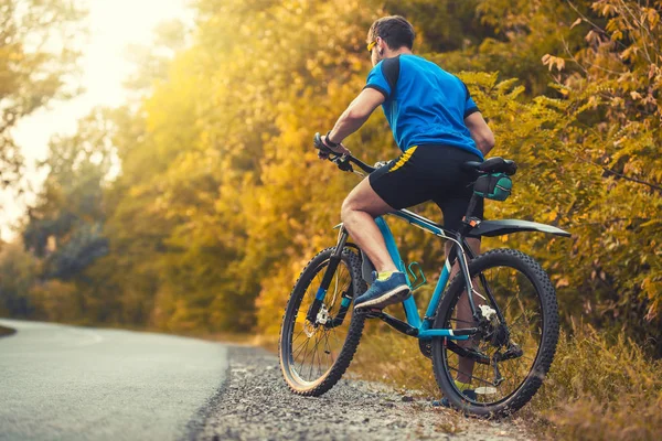 Homem ciclista passeios na floresta em uma bicicleta de montanha . — Fotografia de Stock