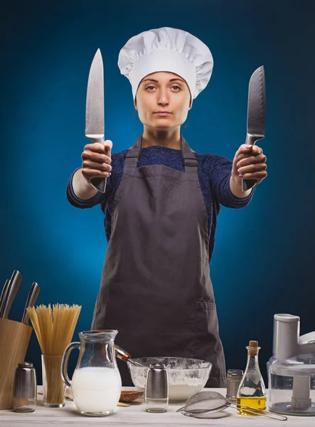 푸른 배경에 맛있는 요리를 준비하는 여자 요리사. — 스톡 사진