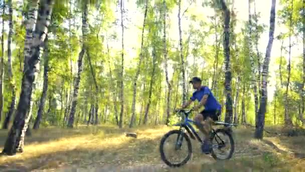 年轻人在一个沉浸的一天在森林道路上骑自行车 — 图库视频影像