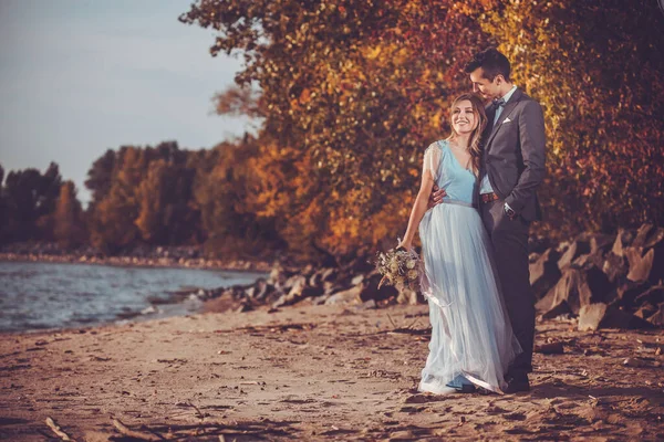 Recém-casados estão andando na praia de outono — Fotografia de Stock