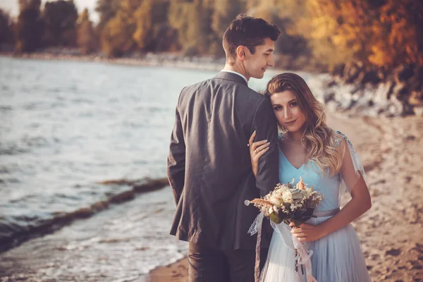 Recién casados están caminando en la playa de otoño — Foto de Stock