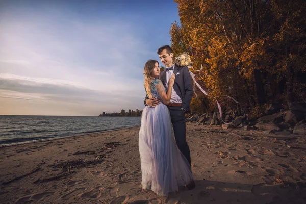 Newlyweds are walking on the autumn beach — Stock Photo, Image