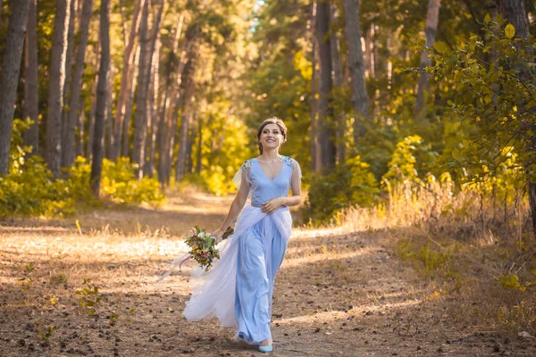 Bruid met boeket loopt door het groene park — Stockfoto