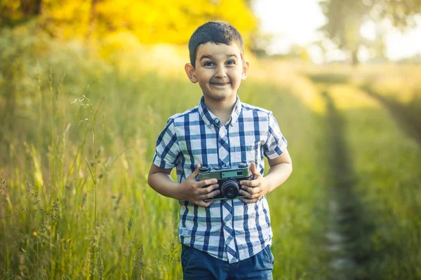 Bonito Menino Sorridente Segurando Uma Câmera Dslr Retro Prado Florescendo — Fotografia de Stock