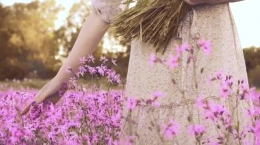 Çiçek açan çayırdaki kadın kır çiçeklerini okşadı