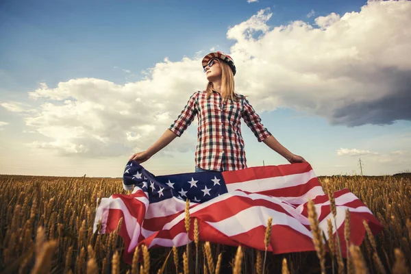 Hermosa Joven Sosteniendo Una Bandera Americana Viento Campo Trigo Paisaje — Foto de Stock