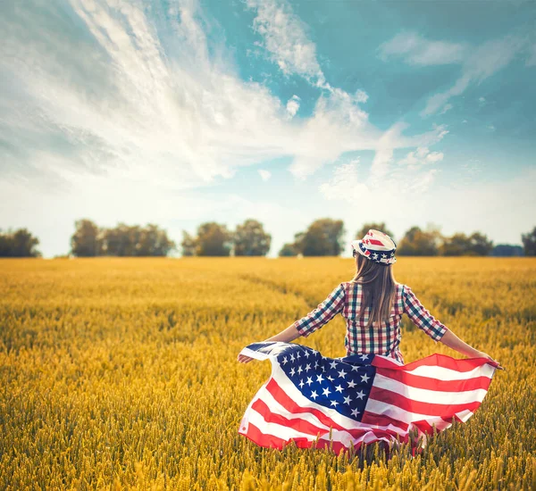 Vacker Ung Flicka Som Håller Amerikansk Flagga Vinden Ett Vetefält — Stockfoto