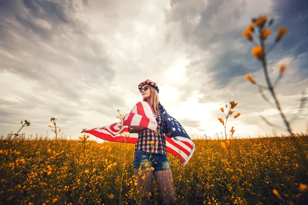 Vacker Ung Flicka Som Håller Amerikansk Flagga Vinden Ett Rapsfält — Stockfoto