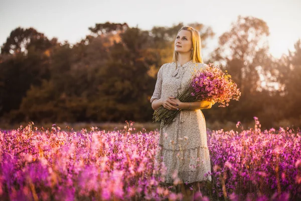 Mladá Žena Kyticí Divokých Květin Stojící Slunné Kvetoucí Louce Západem — Stock fotografie