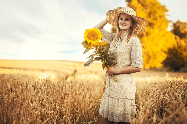 夏の小麦畑でひまわりと帽子を被った白人女性 — ストック写真