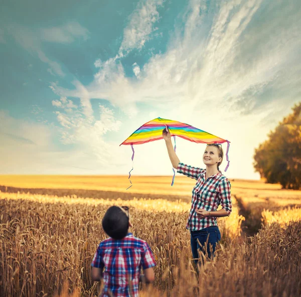 妈妈和儿子在夏天的麦田里放风筝 幸福的家庭 — 图库照片