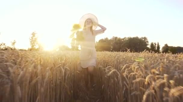 Nő napraforgóval retro ruhában és kalappal a nyári búzamezőn — Stock videók
