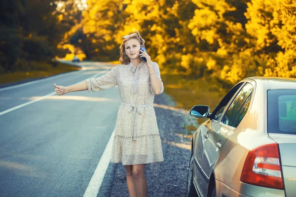 Belle blonde parlant au téléphone près de la voiture. — Photo