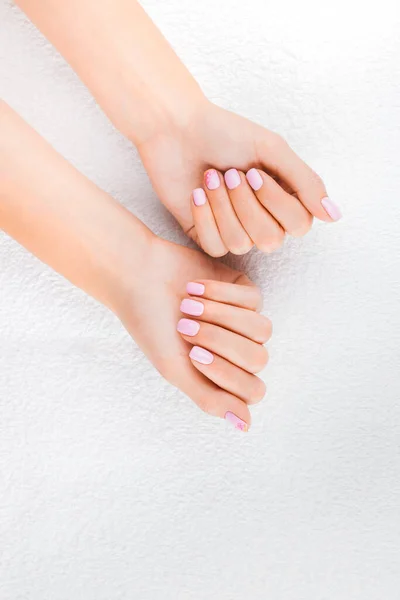 Mãos de mulheres com manicura natural, pele limpa. Unhas rosa claro . — Fotografia de Stock