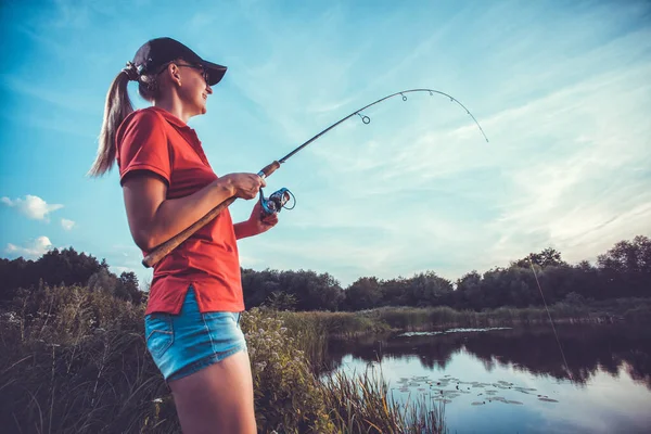 Linda mujer está pescando con caña en el lago —  Fotos de Stock