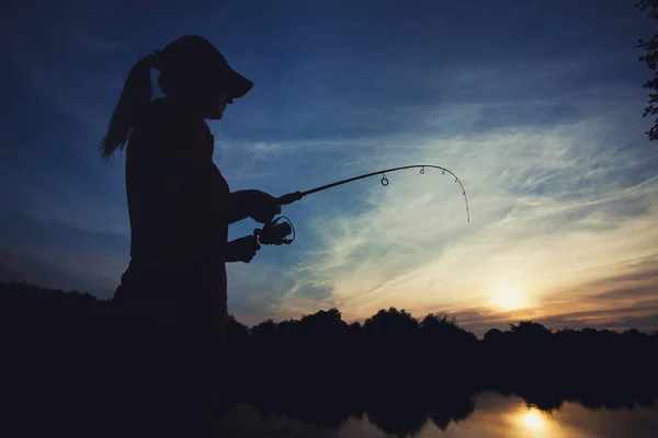 Linda mujer está pescando con caña en el lago — Foto de Stock