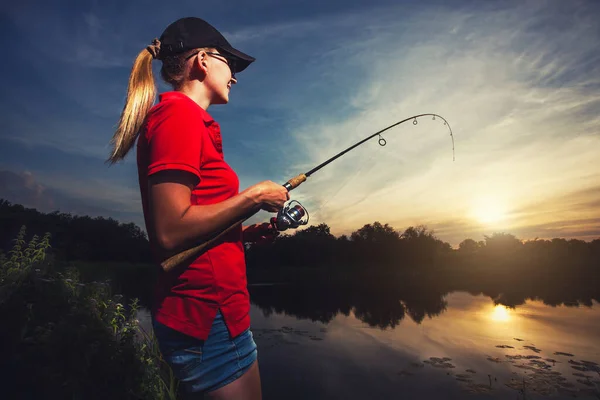 Linda mujer está pescando con caña en el lago — Foto de Stock