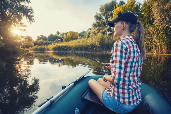 Mujer linda es la pesca con caña en un lago de verano — Foto de Stock