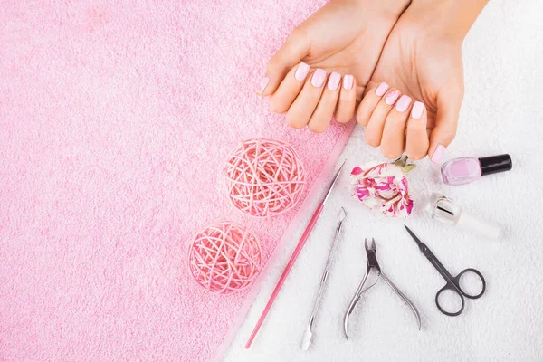 beautiful pink manicure with rose,manicure set, on the white and pink towels. spa concept