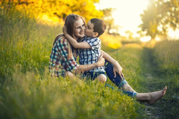 Anne ve oğlu yeşil bir çayırda oynuyorlar. Parkta aktif yürüyüş