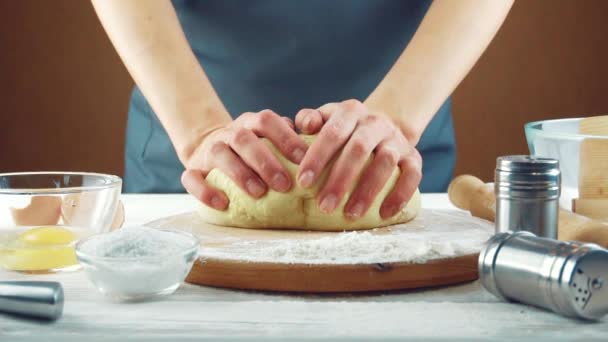 Női szakács gyúrja a tésztát egy fa asztalon. — Stock videók