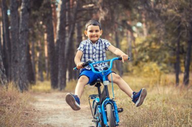 Ormanda bisikletle gezen mutlu çocuk..